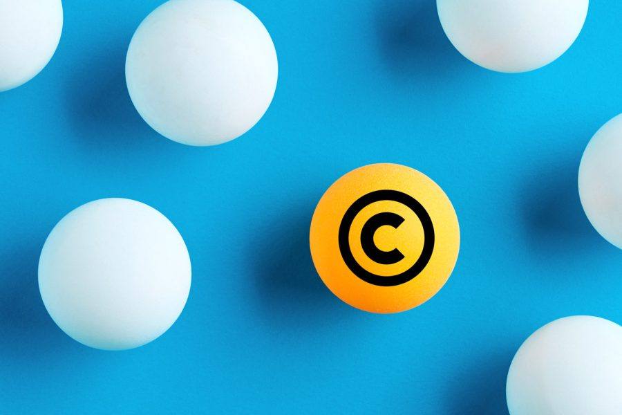 Oranje bal met het copyright-symbool onder witte ballen op een blauwe achtergrond